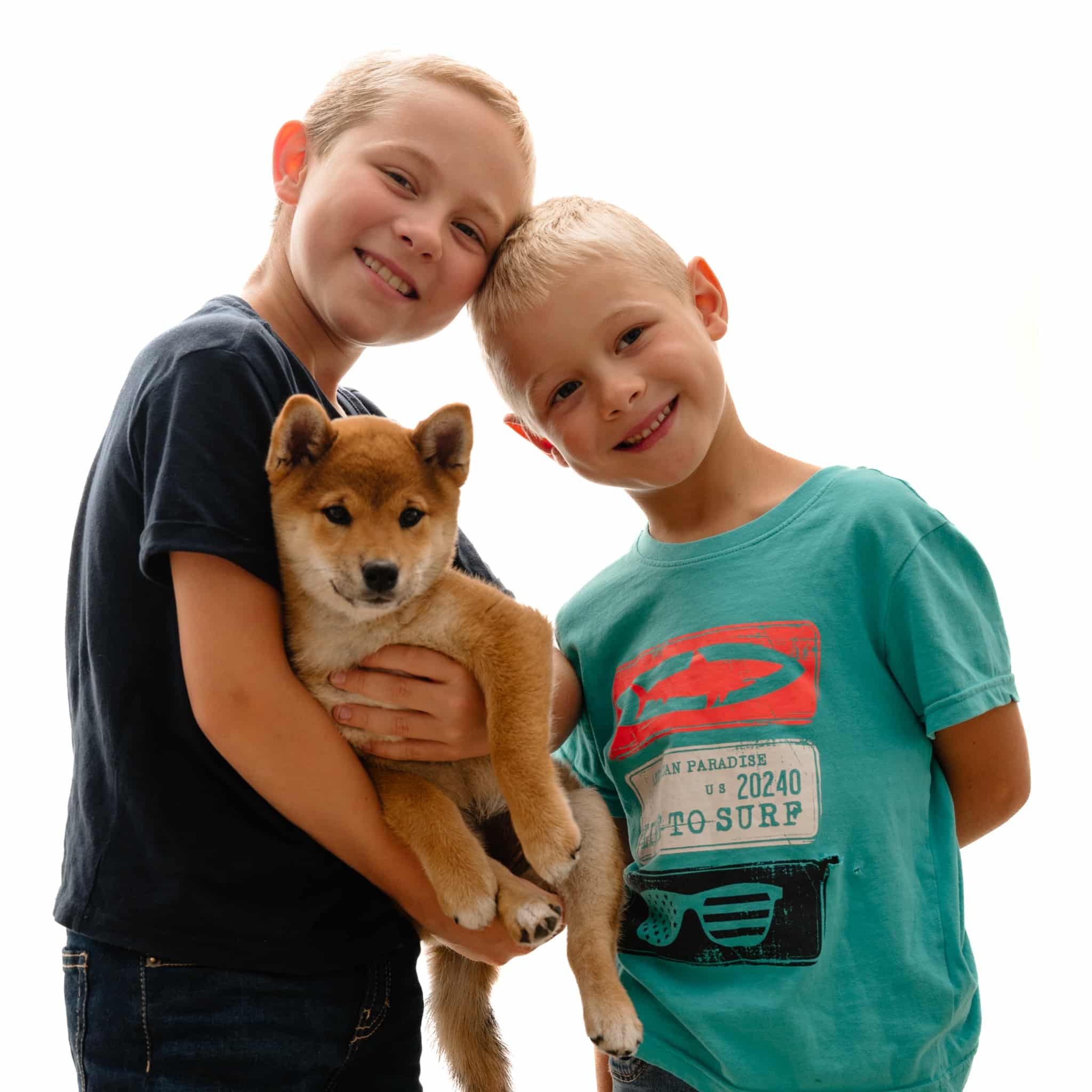Deux enfants avec leur chiot pendant une séance photo de famille à Mouscron