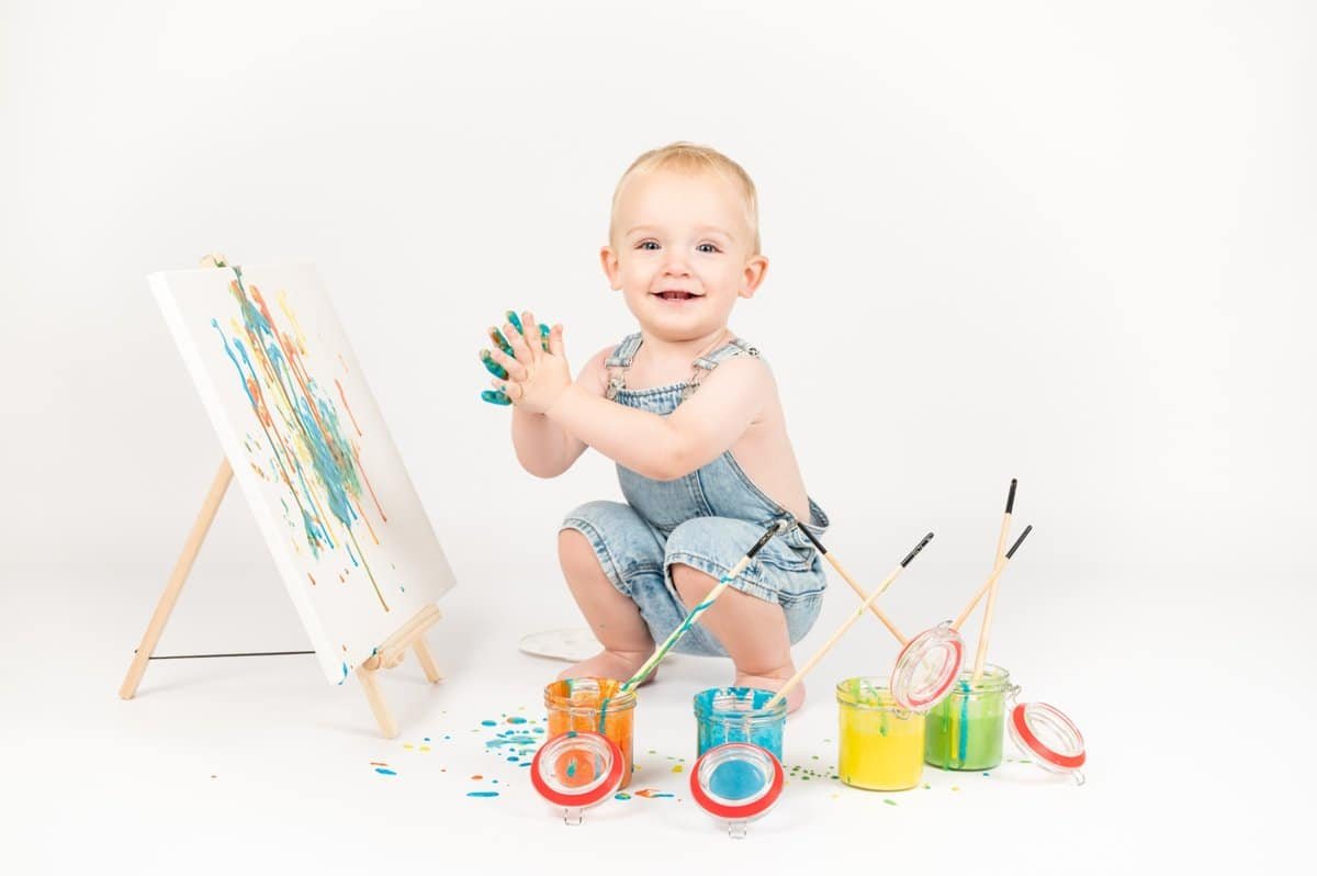 Bambin souriant dans un décor de peinture colorée