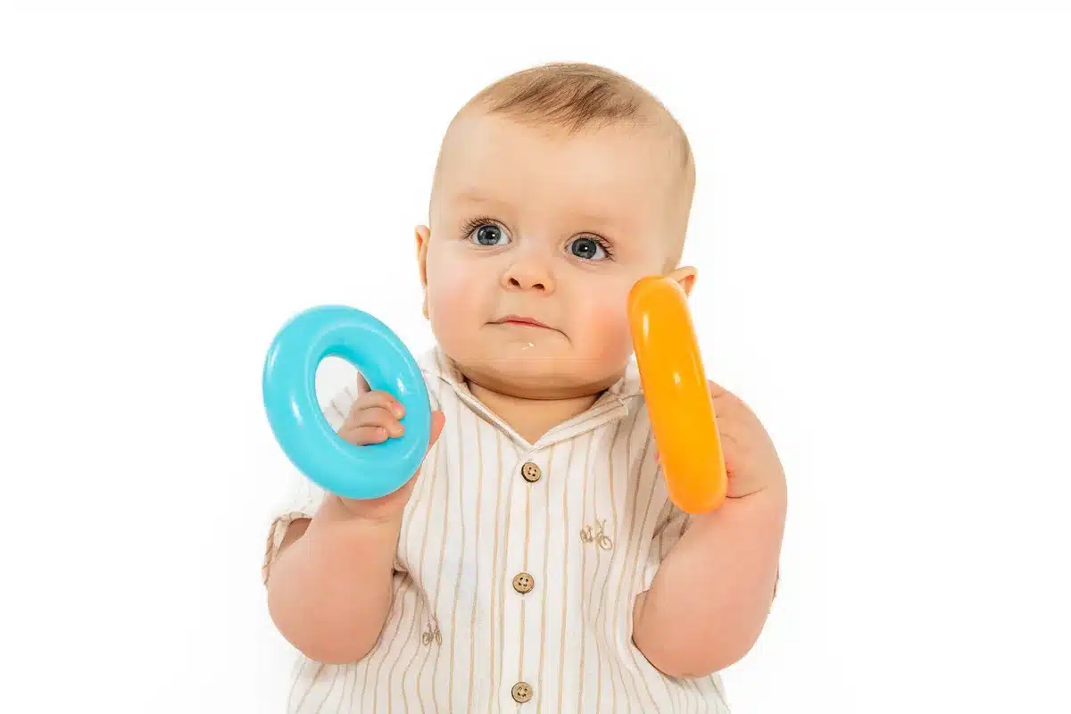 Bébé jouant avec des anneaux colorés au studio